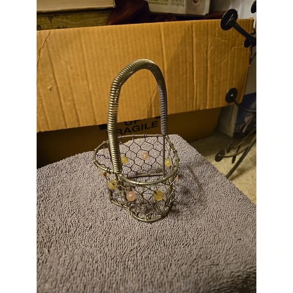 silver-tone wire basket featuring a heart-shaped base and a coiled wire handle
